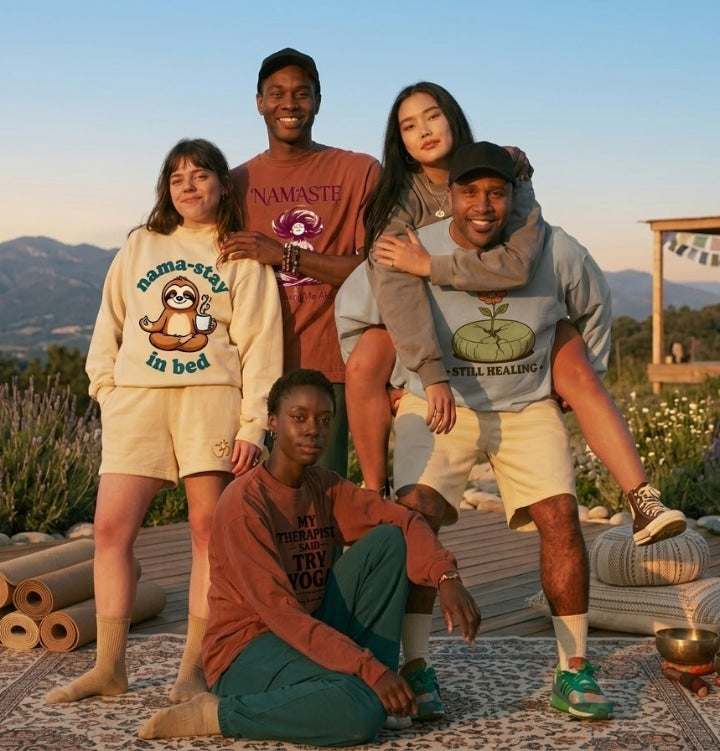 Group of people posing outdoors with mountains and flowers in the background